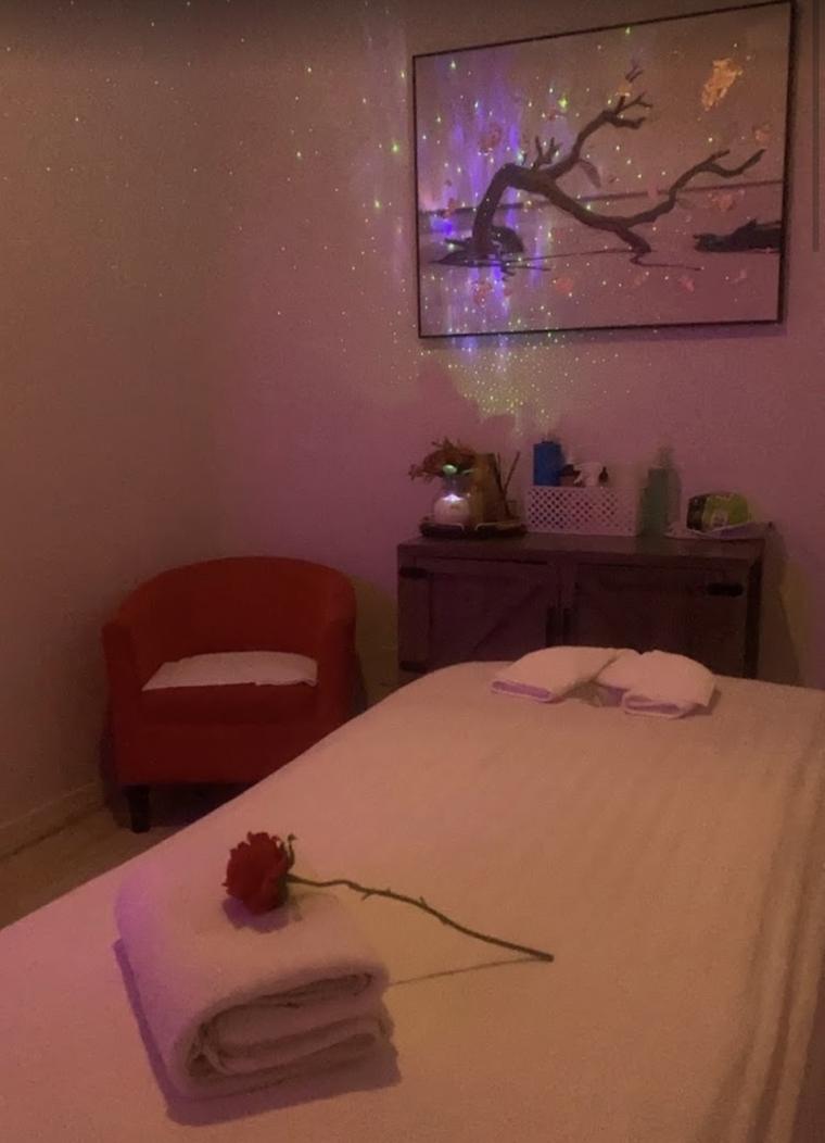 A treatment room with fresh linens, warm low lighting and a chair for your things